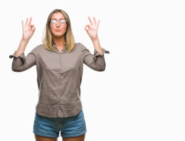 Genç güzel kadın izole arka plan üzerinde dinlenmek ve gülümseyen gözlerle parmak ile meditasyon jest yapıyor kapalı. Yoga kavramı.