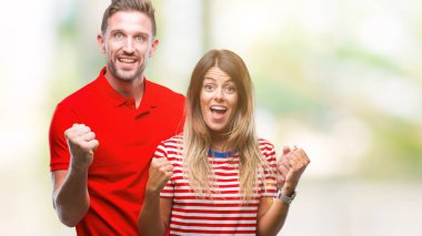 İzole arka plan kutlama üzerinde aşık genç çift şaşırttı ve başarı için kaldırdı kollarını açarak hayret ve gözleri açık. Kazanan kavramı.