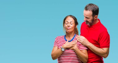 Orta yaş İspanyol kaç sevgi ile gülümseyen izole arka plan üzerinde içinde kapalı gözler ve yüzünde minnettar jest ile göğüs üzerinde eller. Sağlık kavramı.