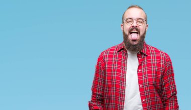 Genç beyaz hipster adam gözlük dilini izole arka plan üzerinde mutlu komik ifade ile dışarı. Duygu kavramı.