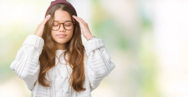 Üzerinde gözlük ve kış şapka giyen genç güzel esmer hipster kadın izole arka plan baş baş ağrısı için el ile çünkü stres. Migren muzdarip.