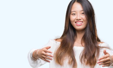 Sarılmak için kollarını açarak gülümseyerek kameraya bakarak izole arka plan üzerinde Genç Asyalı kadın. Neşeli ifade kucaklayan mutluluk.