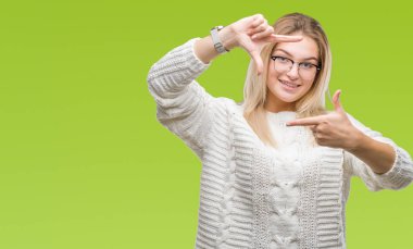 Elle yapma çerçeve ve parmakları ile mutlu yüz gülümseyen izole arka plan üzerinde gözlük takan Genç beyaz kadın. Yaratıcılık ve Fotoğrafçılık kavramı.