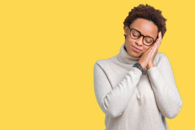 Uyku yorgun hayal ve ellerle birlikte poz ile kapalı gözler gülümseyen izole arka plan üzerinde gözlük takan genç güzel Afrikalı-Amerikalı kadın.