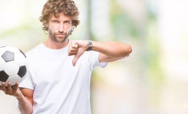 İspanyol yakışıklı modeli futbol futbol topu tutan arka plan kızgın yüzü, eksi işareti aşağı antipati başparmak ile gösterilen, ret kavramı ile izole