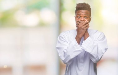 Geleneksel djellaba üzerinde giyen genç Arapça Afrika adam arka plan ağız hata için elleriyle kapsayan şok izole. Gizli kavramı.