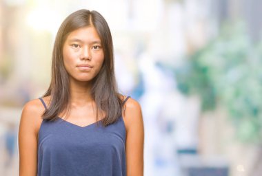 Genç Asyalı kadın yüzünde ciddi bir ifade ile izole arka plan üzerinde. Basit ve doğal kameraya bakıyor.