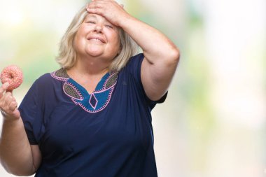 Kıdemli artı boyutu ile izole arka plan üzerinde beyaz kadın yeme şeker çörek vurguladı kafasına, utanç ve sürpriz yüz, öfkeli ve sinirli ile şok ver. Korku ve hata için üzgün.