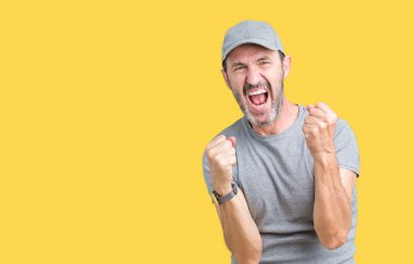 Gülümseyen ve başarı için çığlık izole arka plan çok mutlu ve heyecanlı kaldırdı, silah ile kazanan jest yapıyor üzerinde spor şapkası yakışıklı orta yaş ağarmış komuta sizde. Kutlama kavramı.