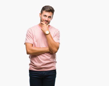 Yakışıklı delikanlı emin çapraz kollar ve çeneme kaldırdı el ile gülümseme ile kameraya bakarak izole arka plan üzerinde. Pozitif düşünce.