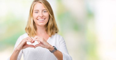 Güzel genç zarif kadın kalp simgesi ve elleriyle şekil gösterilen aşık gülümseyen izole arka plan yüzünden. Romantik kavramı.