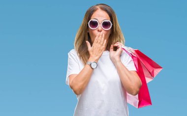 Hata, korku, sessizlik içinde gizli kavramı korkmuş ifade için utanç ile izole arka kapak ağız el ile üzerinden satış alışveriş torbaları tutan orta yaş İspanyol kadın şok