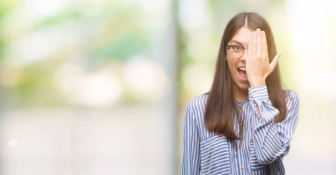 Genç güzel İspanyol iş kadını elle yüz ve sürpriz duygu kendinden emin gülümseme ile bir göz kapsayan.