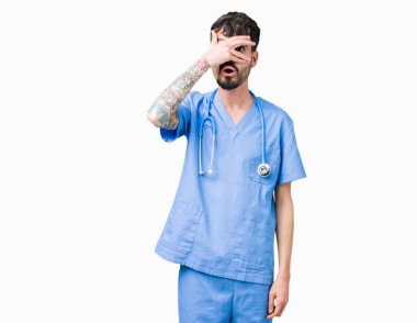 Genç yakışıklı yüz ve gözler el ile kapsayan şok izole arka plan bakmak üzerinde cerrah üniforma giyen adam utanç ifadesi ile parmaklarımın arasından bakan hemşire.