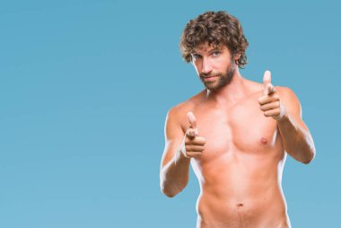 Yakışıklı İspanyol modeli adam seksi ve gömleksiz izole arka plan fotoğraf makinesi ile mutlu ve komik yüz için parmakları işaret içinde. İyi enerji ve vibes.