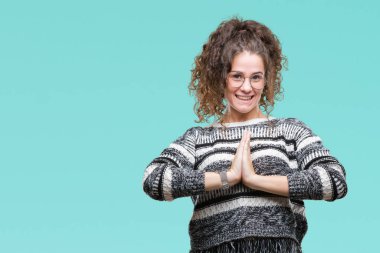 Güzel esmer kıvırcık saçlı Genç kız üzerinde gözlük takan ellerle birlikte AF emin gülümseyen için soran dua arka plan izole.