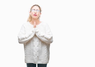 Yalvarıyor ve umut ifade yüzünde çok duygusal ve endişe ile birlikte elleriyle dua izole arka plan üzerinde gözlük takan genç güzel sarışın kadın. Bağışlanmak. Din kavramı.