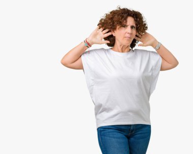 Bir işitme söylenti ya da dedikodu için dinleme kulak üzerinde el ile gülümseyen izole arka plan üzerinde beyaz t-shirt giyen güzel orta ager kadın kıdemli. Sağırlık kavramı.