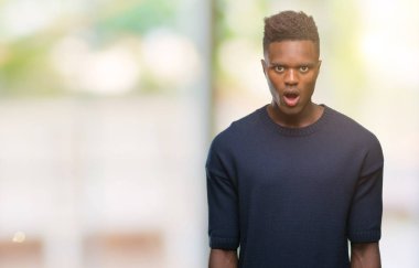 Genç Afro-Amerikan adam korkuyor ve şok sürpriz ifade ile izole arka plan üzerinde korku ve yüz heyecanlı.