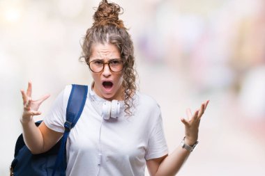 Sırt çantası ve kulaklık üzerinde giyen genç esmer öğrenci kız arka plan deli izole ve deli bağırarak ve agresif ifade ve silah kaldırdı bağırıyor. Hayal kırıklığı kavramı.