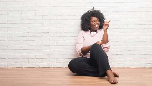 Joven Mujer Afroamericana Sentada Suelo Usando Auriculares Con Una Gran — Foto de Stock