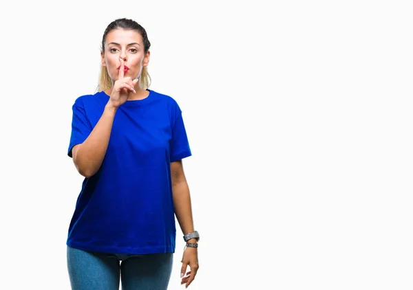 年轻美丽的女人穿着休闲蓝色 T恤在孤立的背景要求安静的手指在嘴唇上 沉默和秘密概念 — 图库照片