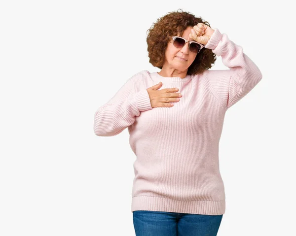 美しい中間エイガー年配の女性にピンクのセーター サングラスを着て背景を分離した病気 インフルエンザ ウイルスの病気のための額に触れる — ストック写真