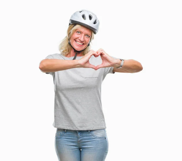 中年白人のサイクリストの女性恋ハートマークと手で形を示す笑みを浮かべて分離の背景に安全ヘルメット身に着けています ロマンチックな概念 — ストック写真