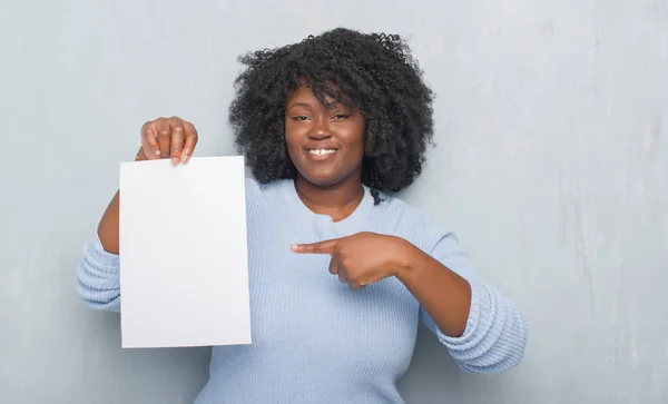 Jonge African American Vrouw Grijs Grunge Muur Holding Blanco Papier — Stockfoto