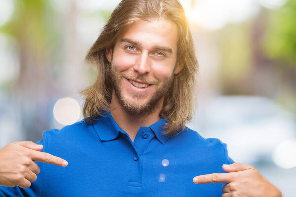 Young handsome man with long hair over isolated background looking confident with smile on face, pointing oneself with fingers proud and happy.
