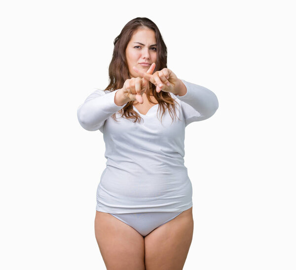 Beautiful plus size young overwight woman wearing white underwear over isolated background Rejection expression crossing fingers doing negative sign