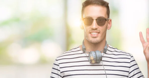 Hombre Joven Guapo Con Auriculares Que Muestran Señalan Hacia Arriba —  Fotos de Stock