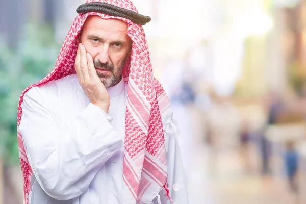 疲れと組んだ腕のうつ病問題にうんざりして孤立した背景を考えての上クーフィーヤ身に着けているアラブの年配の男性 — ストック写真