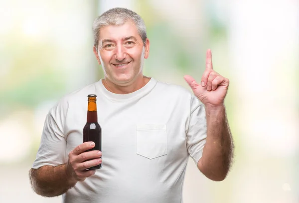 ハンサムな年配の男性を飲むビール ボトル分離アイデアや質問 ナンバーワンの幸せそうな顔で指を指していると驚かれる背景 — ストック写真