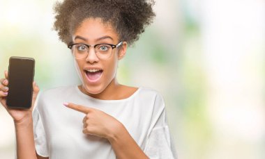 Genç güzel afro Amerikan smartphone ekran üzerinde gösterilen arka plan el ve parmak ile işaret çok mutlu izole.