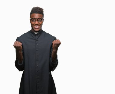 İzole arka plan kutlama üzerinde genç Afro-Amerikan rahip adam şaşırttı ve silah ile başarı için yükseltilmiş ve açık gözler hayrete düşürdü. Kazanan kavramı.