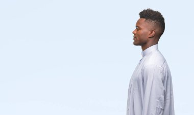 Geleneksel djellaba izole arka tarafına, seyir üzerinde giyen genç Arapça Afrika adam sakin ol kendine güvenen gülümseme ile doğal yüz pozuyla profili.