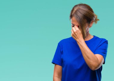 Orta yaş İspanyol kadın kıdemli izole arka plan yorgun sürtünme burun ve göz yorgunluğu ve baş ağrısı hissediyor. Stres ve hayal kırıklığı kavramı.