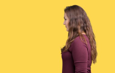 Güzel ve çekici artı boyutu genç kadın üzerinde izole arka tarafına bakarak bir elbiseyle, doğal yüz emin gülümseme ile pozuyla profil sakin ol.