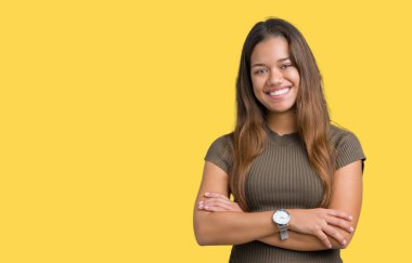 İzole arka plan mutlu yüz çapraz silah kameraya bakarak ile gülümseyen genç güzel esmer kadın. Olumlu bir kişi.