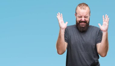 Genç beyaz hipster adam arka plan deli kutluyor izole ve yükseltilmiş ve kapalı gözleri çığlık çılgın silah ile başarı için heyecanlı. Kazanan kavramı