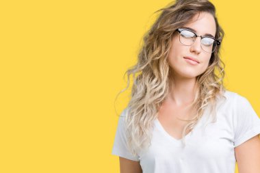 Gözlüklü seksi bir ifadeyle, neşeli ve mutlu yüzünü kameraya bakarak göz kırpıyor izole arka plan üzerinde güzel sarışın genç kadın.