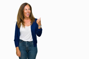 Seyir ve başparmak yanında yukarıyı mutlu yüz ile gülümseyen izole arka plan güzel orta yaş rahat yetişkin kadın.