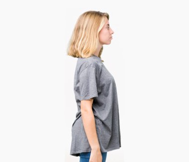 İzole arka tarafına, seyir üzerinde büyük boy rahat t-shirt giyen güzel genç kadın dinlenmek doğal yüz emin gülümseme ile pozuyla profili.