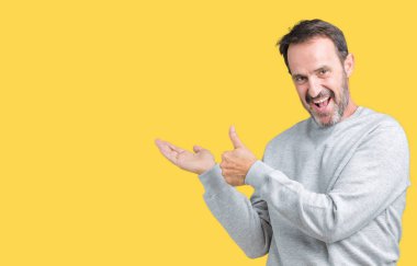 Yakışıklı orta yaş üzerinde bir kazak giyen adam arka plan gösteren palm el izole ve ok hareketini yapıyor, mutlu ve neşeli gülümseyen Yaşasın üst düzey