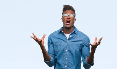 Genç Afro-Amerikan adam izole arka plan çılgın ve kızgın bağırarak ve agresif ifade ve silah kaldırdı bağırıyor. Hayal kırıklığı kavramı.