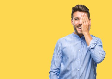 El yüz ve sürpriz duygu kendinden emin gülümseme ile tek gözüyle kapsayan izole arka plan üzerinde genç yakışıklı adam.