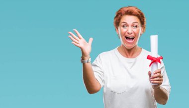 Derecesi sertifika tutan üst düzey beyaz kadın büyük gülümseme ile çığlık zaferini kutluyor arka plan çok mutlu ve heyecanlı, kazanan ifade izole ve ellerini kaldırdı