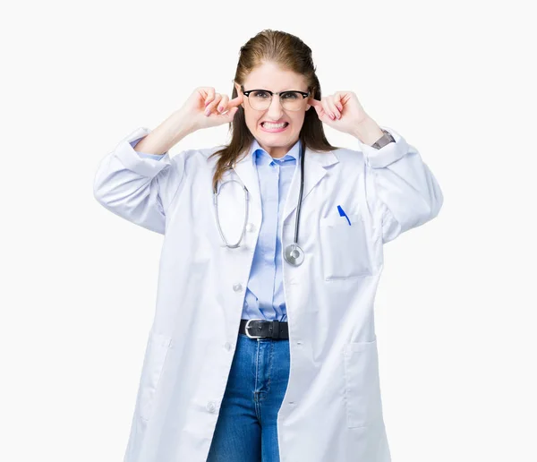 中年成熟的医生妇女穿着医疗外套在孤立的背景覆盖耳朵与手指与愤怒的表达为响亮的音乐的噪音 聋哑人的概念 — 图库照片