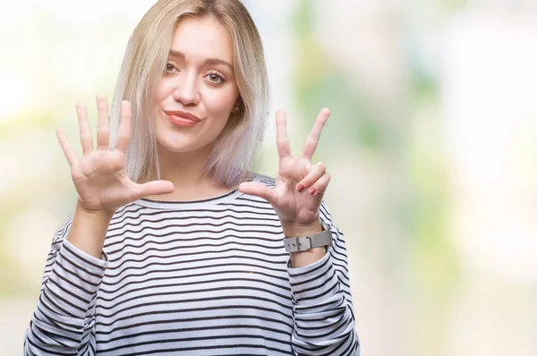 Genç Sarışın kadın gösterilen ve parmakları ile işaret izole arka plan yüzünden kendinden emin ve mutlu gülümseyerek süre 8 numaralı.